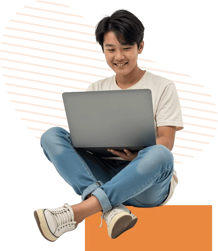 smiling boy using laptop crosslegged